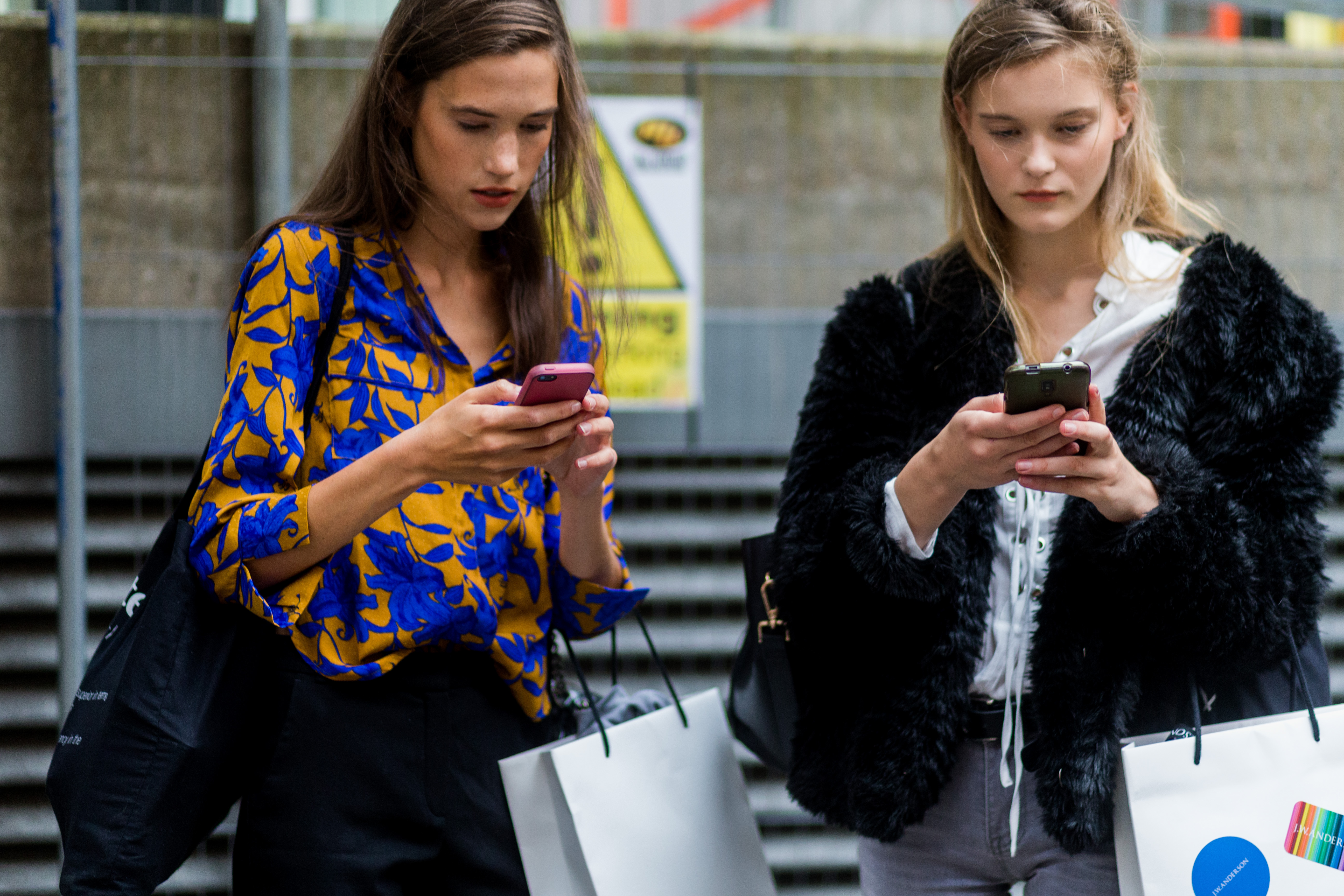 LONDON, ENGLAND - SEPTEMBER 17: Models on their phone outside of JW Anderson during London Fashion Week Spring/Summer collections 2017 on September 17, 2016 in London, United Kingdom. (Photo by Christian Vierig/Getty Images)