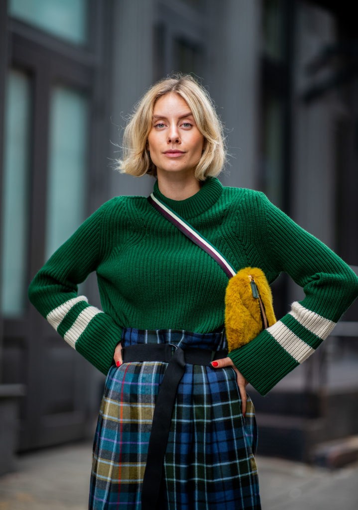 NEW YORK, NY - SEPTEMBER 12: Lisa Hahnbueck wearing checked pants Tibi, green knit Baum und Pferdgarten, yellow fake fur belt bag, sandals Roger Vivier is seen during New York Fashion Week Spring/Summer 2019 on September 12, 2018 in New York City. (Photo by Christian Vierig/Getty Images) | 30 chic and contemporary ways to wear the colour green