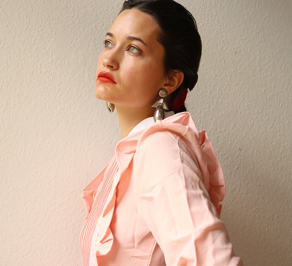 Depop seller Abbey Looker wearing red lipstick and a pink ruffled blouse