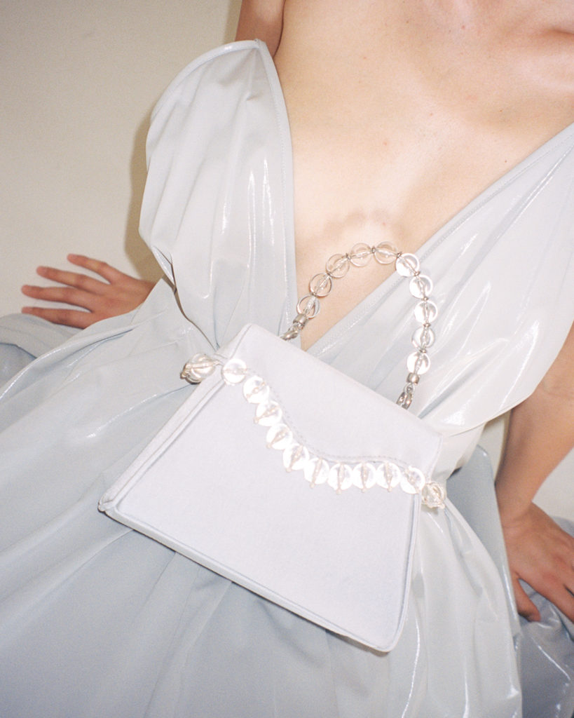 model in white paris georgia dress with with mini bag from Paris Georgia x By Far